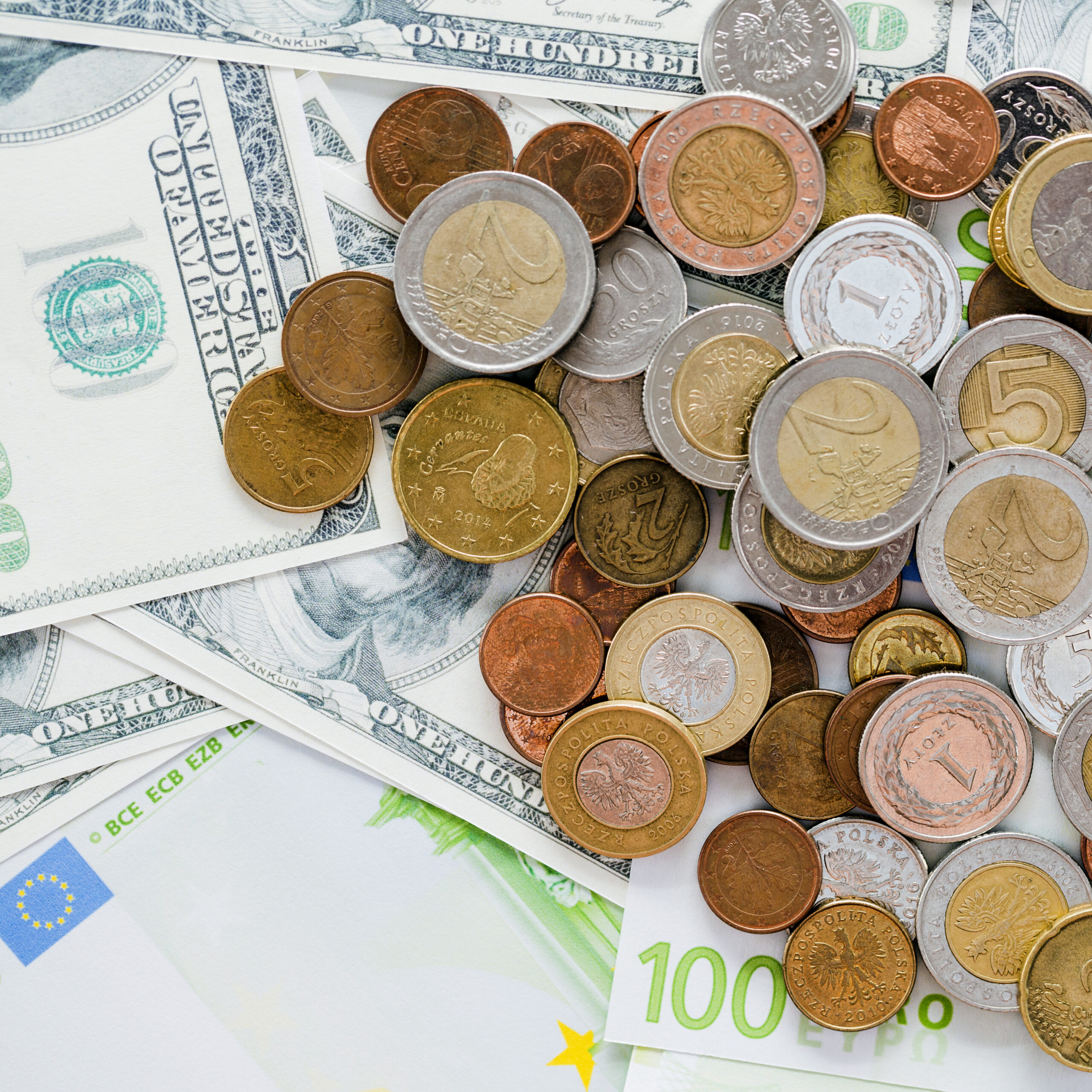 close-up-spread-coins-us-one-hundred-dollar-bills